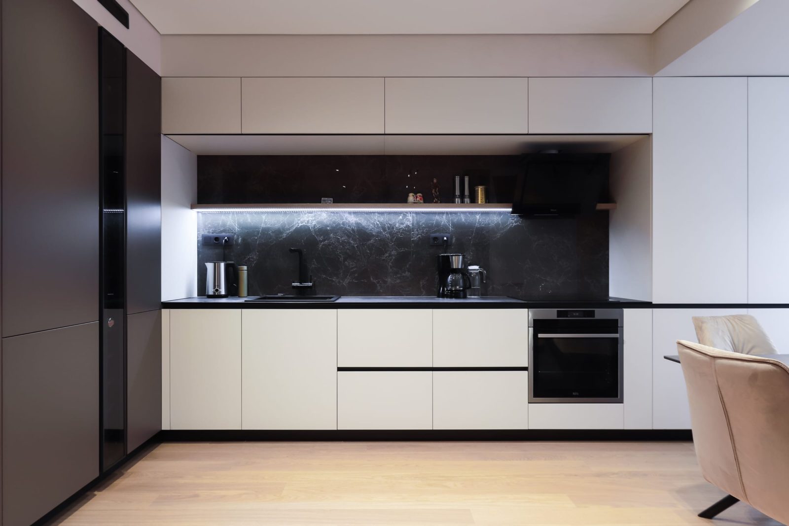 White kitchen with dark splashback and under-cabinet light