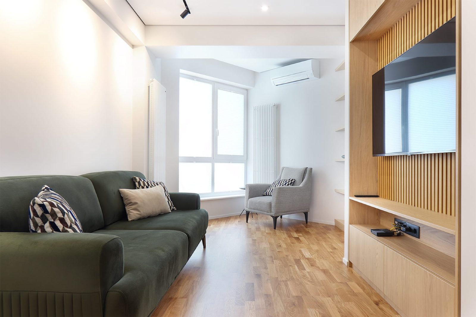 Green sofa facing the oak TV unit