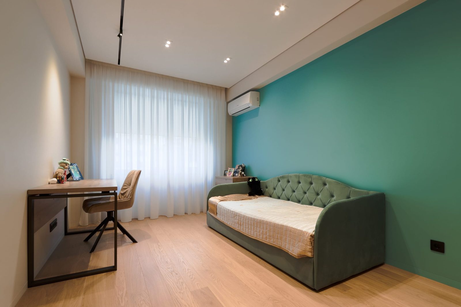 Child’s room with teal wall and daybed